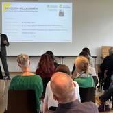Landrat Dr. Fiedler begrüßt Gäste, während eine Präsentation mit dem Titel "HERZLICH WILLKOMMEN" im Hintergrund auf der Leinwand angezeigt wird.
