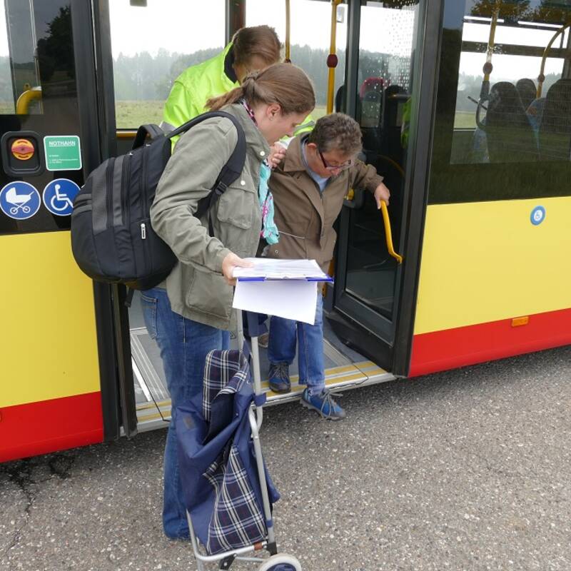 Heike Goller-Lenz hilft einer Frau mit Gehbehinderung beim Ausstieg aus dem Bus