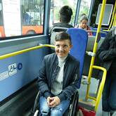 Eine lachende Rollstuhlfahrerin auf dem Rollstuhlplatz in einem Bus