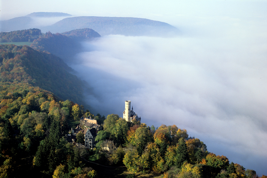 Luftbild auf das Schloss Lichtenstein, seitlich Nebel und Wald